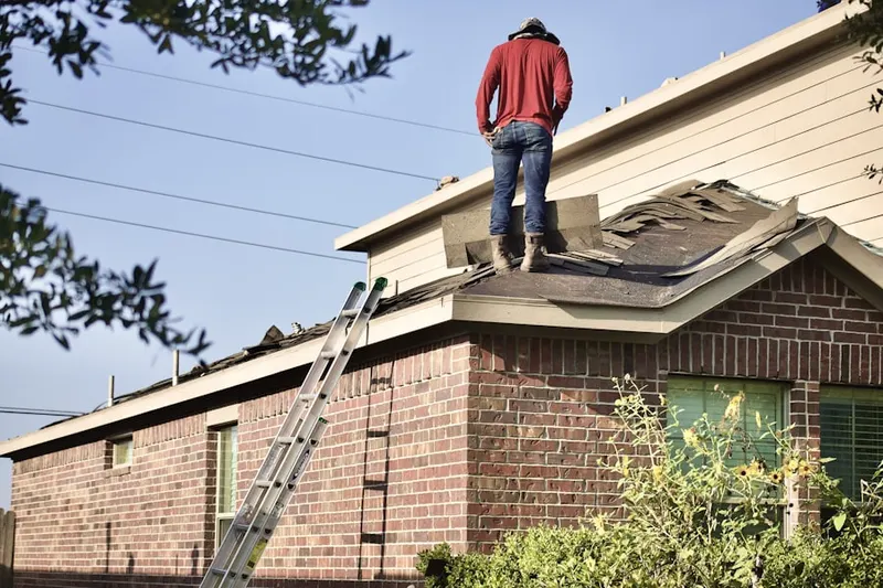 Professional roofer working on a residential roof in Estates of Auburndale
